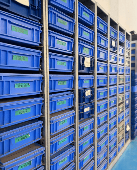 Contenitori blu organizzati sugli scaffali del reparto logistico